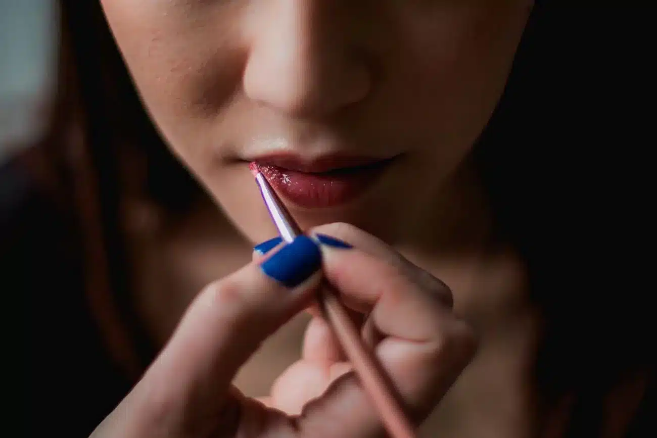 Aplicación profesional de maquillaje en párpado con pincel especializado para servicios de belleza