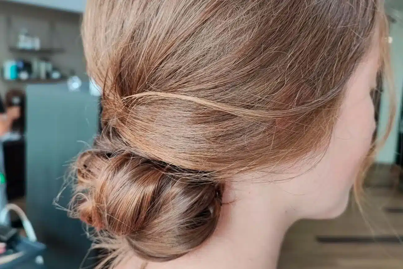 Moño bajo elegante recogido en cabello castaño claro para peinados de ocasiones especiales